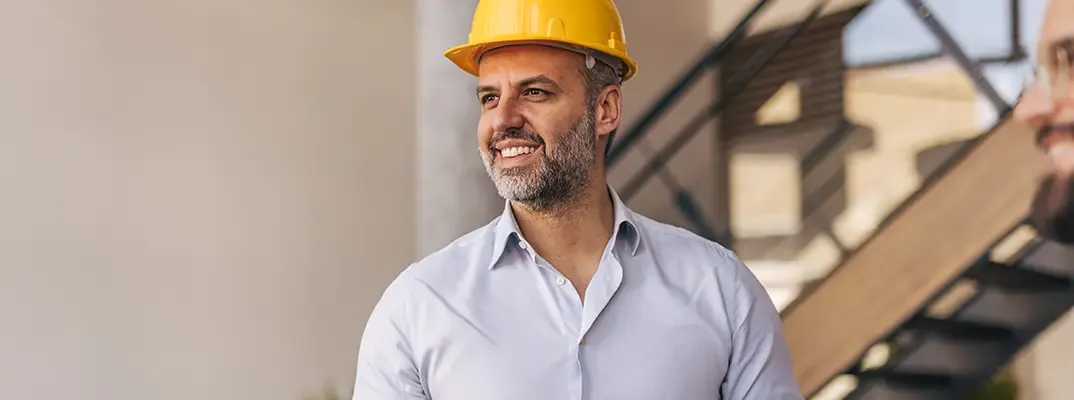 A man in a button up shirt and hard hat