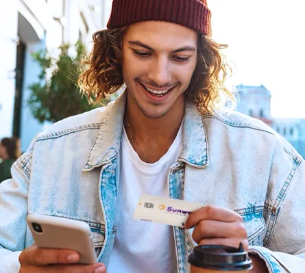 A man with a smart phone holding a Visa Platinum Rebate Credit Card