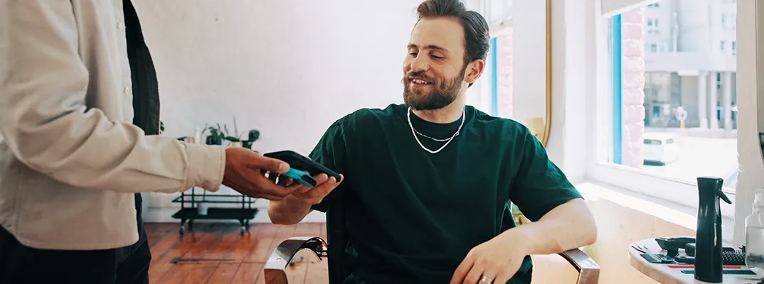 A man paying for a haircut with Google Pay.