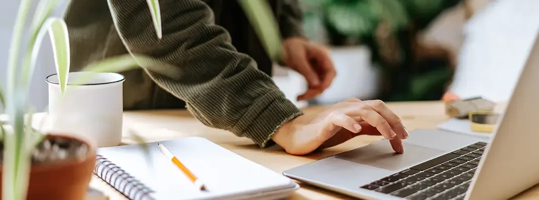 A hand typing on a laptop