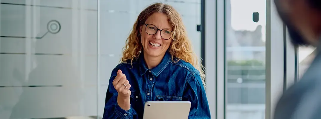 A smiling woman with a tablet.