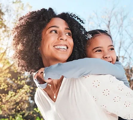 A woman giving her daughter a piggy-back ride.