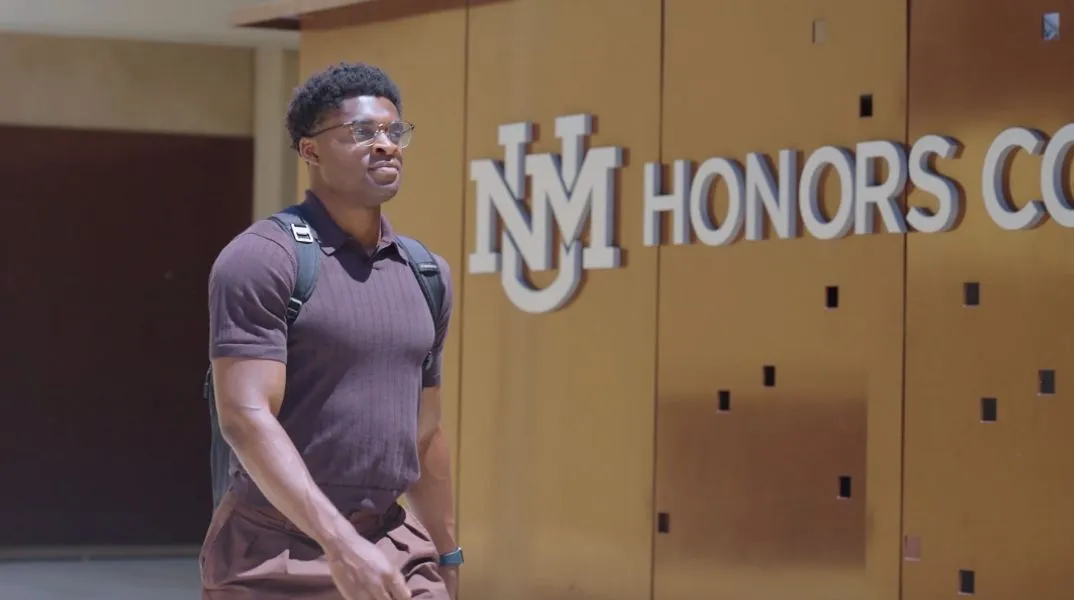 Solomon Gbara, Sunward scholarship recipient, walking on the UNM campus near the Honors College building.