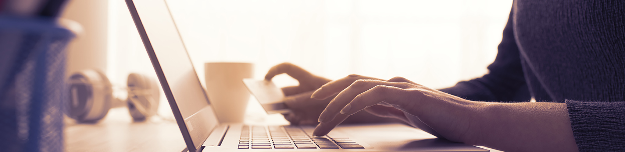 Woman holding credit card and using laptop