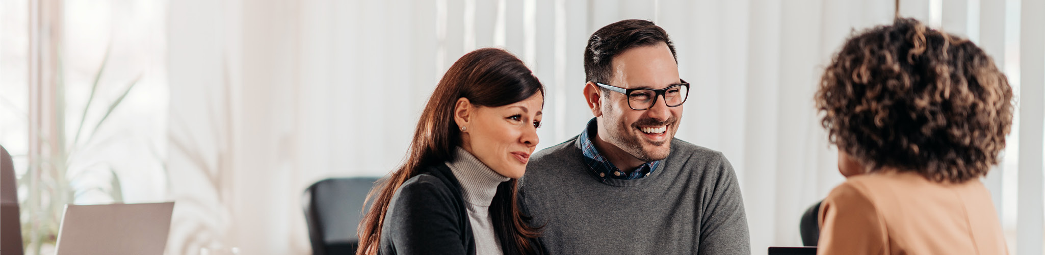 Smiling couple meeting with financial advisor