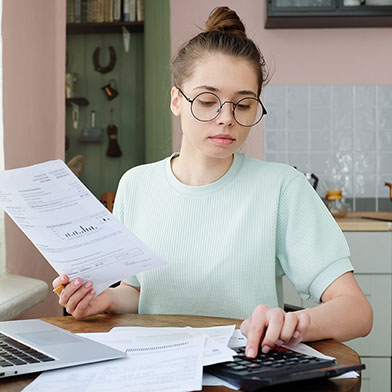 Young woman at table looking at papers