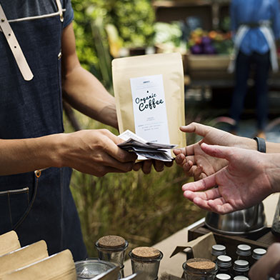 Person buying organic coffee from small business.