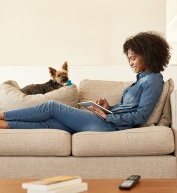 Women looking at a tablet computer with her dog.