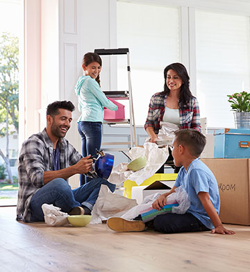 Family unpacking boxes in their new home