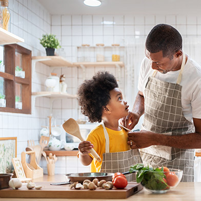 Father and son cooking together in trendy, recently renovated kitchen.