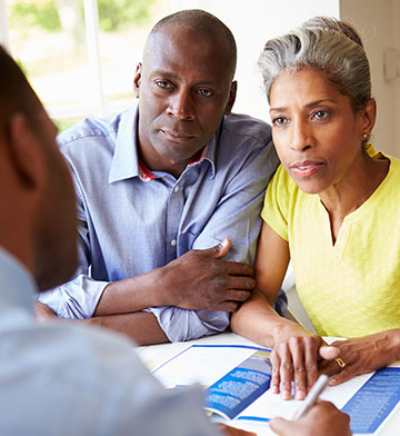 Couple sitting at desk and talking to a financial advisor