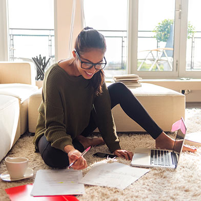 Young adult at home surrounded by paperwork