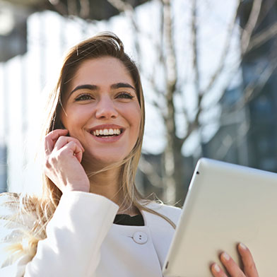 Woman talking on cellphone and holding tablet