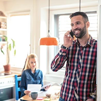 Man smiling and talking on a cell phone.