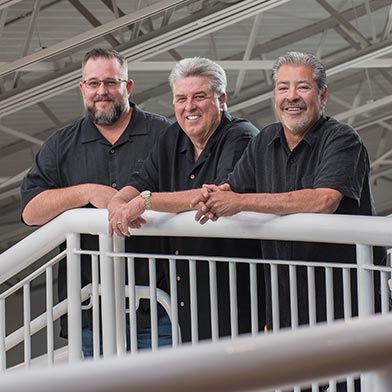 Pictured on the Explora Science Museum staircase that Raysteel, Inc. helped  fabricate are Tommy Ray, Ken Ray, and Mike Atencio (left to right).