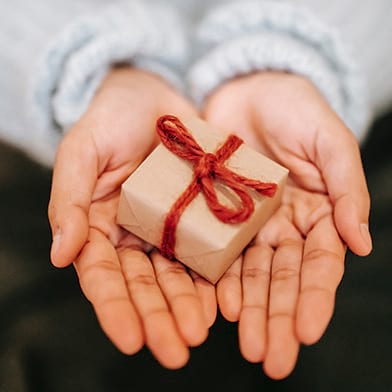 Hands holding small wrapped gift