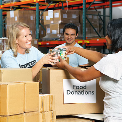 Woman taking canned goods for holiday food donations