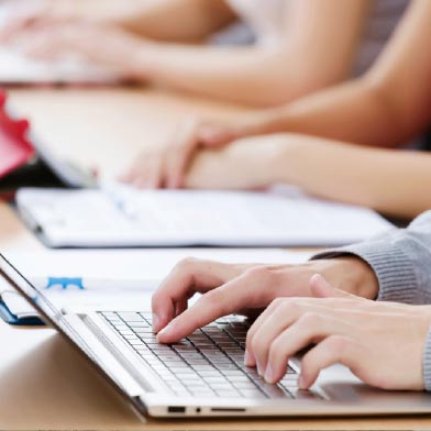 Close up photo of someone typing on a laptop in class