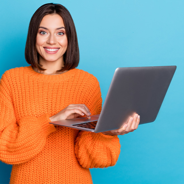 Man and woman leaning on kitchen counter looking at their laptop screen