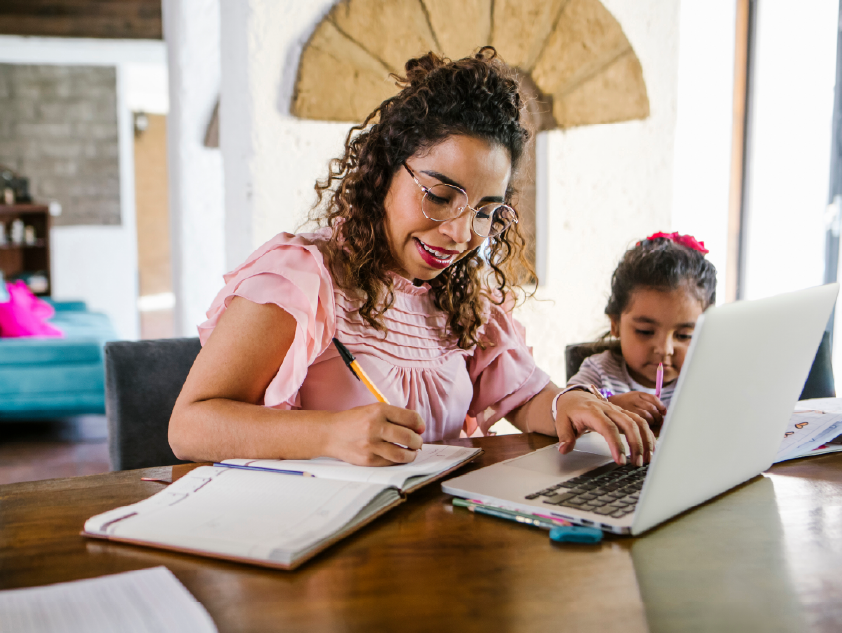 A mother and daughter planning a budget using a laptop and notebook